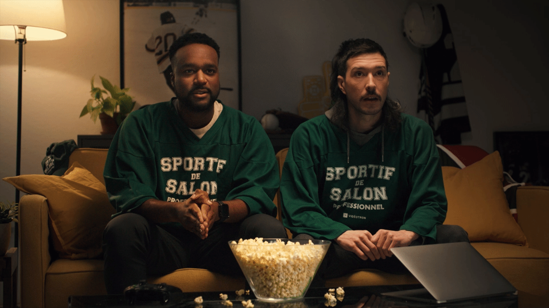 Two men watching TV on a couch